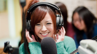 Smiling asian woman headphones green - a green sweater free wallpaper
