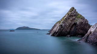 Ocean rock mountain shore sky - a mountain in the background and a body of water free wallpaper