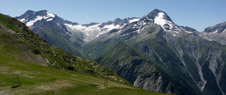 Mountain range grassy field snow - a grassy field below free wallpaper
