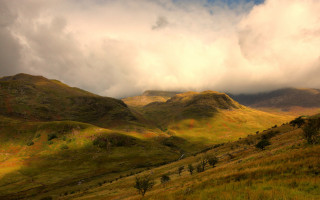 Grassy field mountains cloudy sky 2 - dramatic light free wallpaper for desktop