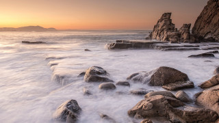 Rocky beach sunset island ocean 2 - a small island in the distance free wallpaper