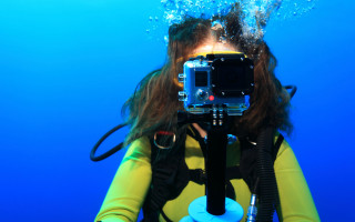 Woman yellow wetsuit underwater camera - free technology wallpaper
