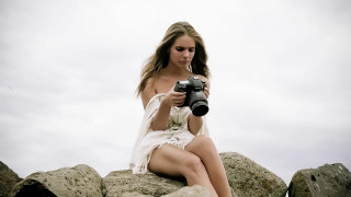 Woman sitting rock camera sky - her hand and a camera free wallpaper
