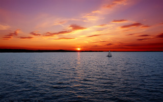 Sailboat sunset water mountain city - a red sky free wallpaper