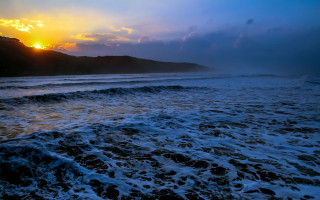 Sunset mountains ocean waves citylights - a mountain in the distance free wallpaper