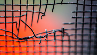 Wire fence closeup red background - mesh wire free wallpaper