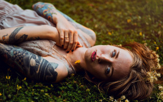 Tattooed woman lying in grass - tattoo free wallpaper