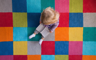 Toddler colorful rug book argyle - a book in her hand and a book in her other hand free wallpaper