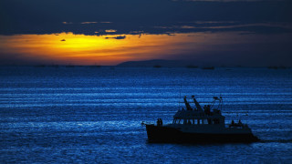Sunset ocean boat clouds cityscape 2 - a boat floating free wallpaper