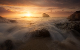 Sunset rocky beach waves distant - a sunset over a rocky beach free wallpaper