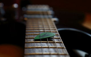 Green guitar pick on guitar - string free wallpaper