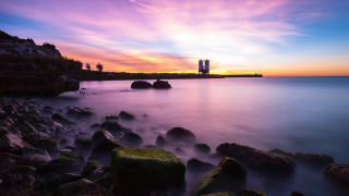 Sunset rocky beach lighthouse mystical - a sunset over a rocky beach free wallpaper
