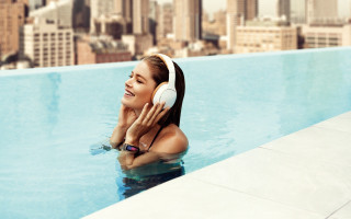 Woman pool headphones smiling cityscape - a city skyline in the background free wallpaper