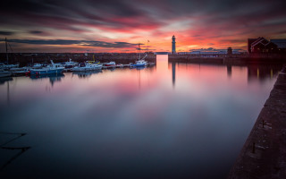 Harbor boats lighthouse sunset cloudy - a lighthouse in the distance free wallpaper