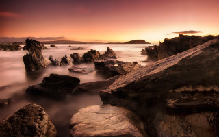 Sunset rocky beach mountains cityscape - rich moody colour free wallpaper