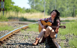 Woman sitting train track guitar - her hand and a smile free wallpaper