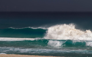 Large wave breaking beach surfers - a surfer free wallpaper