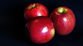 Three red apples black surface - top of them free wallpaper