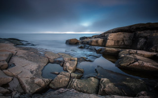 Rocky shore sunburst ocean mountains - artur grottger free wallpaper