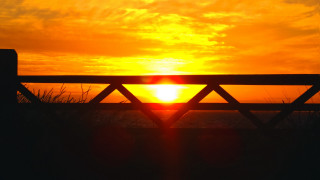 Sunset beach wooden fence grass - the foreground and a body of water free wallpaper for desktop