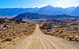 Desert dirt road mountains clouds - free vintage wallpaper