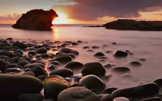 Rocky beach sunset mountain clouds 2 - a rock formation in the middle of it free wallpaper