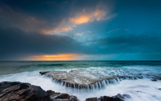 Ocean rock sunset clouds island - a rock formation in the ocean free wallpaper