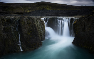 Waterfall mountain bodywater rock sky - a waterfall in the middle of it free wallpaper