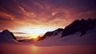 Sunset mountain snow clouds distant - a sunset over a mountain range free wallpaper