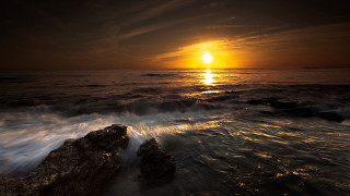 Sunset ocean waves rocks boat 2 - a sunset over the ocean free wallpaper