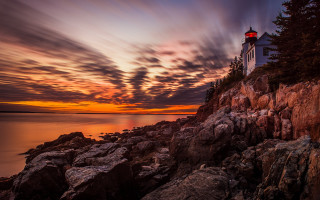 Lighthouse rocky cliff sunset clouds - a rocky cliff free wallpaper