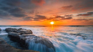 Sunset ocean waves rocks person - a sunset over the ocean free wallpaper
