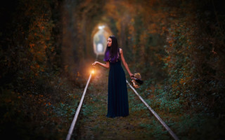 Woman holding light traintrack woods - magical atmosphere free wallpaper