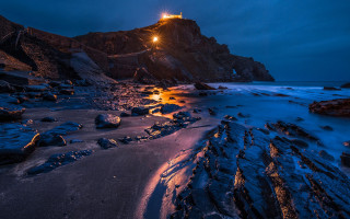 Lighthouse rocky cliff night shining - free winter wallpaper