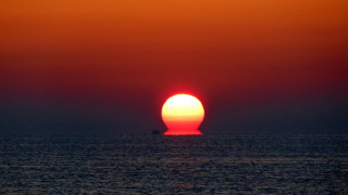 Orange sun over ocean surrealist - free sunset wallpaper