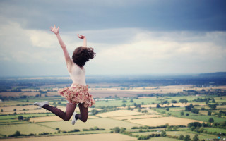 Woman jumping countryside beach sky - cheerful free wallpaper