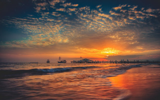 Sunset beach pier boat clouds - a sunset over a beach free wallpaper