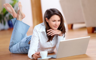 Woman laying on floor laptop - her stomach free wallpaper