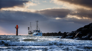 Boat lighthouse rocky shore stormy - a lighthouse in the background free wallpaper