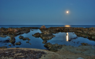 Full moon ocean rocks lighthouse - a lighthouse in the distance free wallpaper