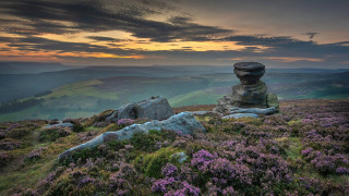 Rock formation grassy hill purple - the foreground and a sunset in the background free wallpaper for desktop