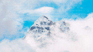 Snowy mountain blue sky plane - cloud below free wallpaper