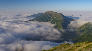 Mountain clouds horizon ocean sunset - a few cloud below free wallpaper