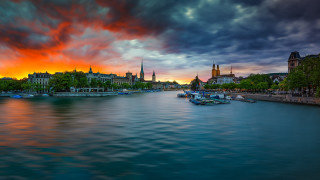 River boats cloudy sunset cityscape - a city in the distance free wallpaper