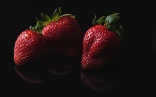 Three strawberries black surface reflection - claire dalby free wallpaper for desktop