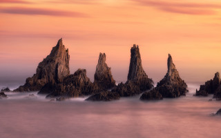 Rock water pink sky sunset - a group of rocks free wallpaper