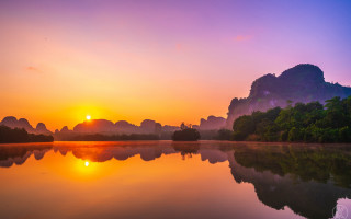 Sunset lake mountains trees boats - a beautiful sunset over a lake free wallpaper