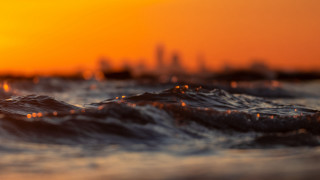 Blurry city skyline sunset waves - orange sky free wallpaper