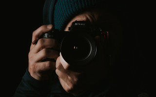 Man holding camera dark hat - nikon free wallpaper for desktop