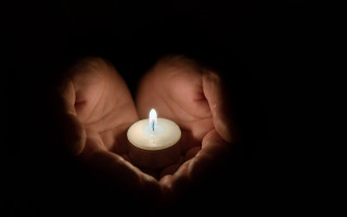 Person holding lit candle dark 3 - their hands in free wallpaper